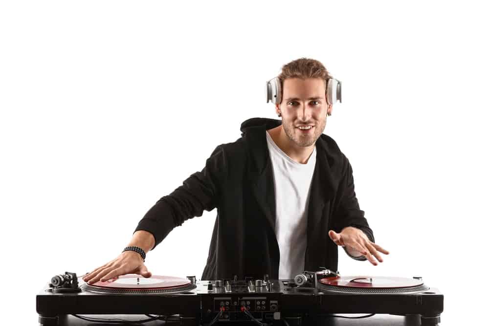 caucasian guy djing as hobby for guys. Has turntable and headphones