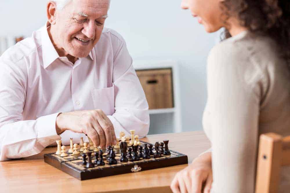 Caucasian male and mixed female playing chess