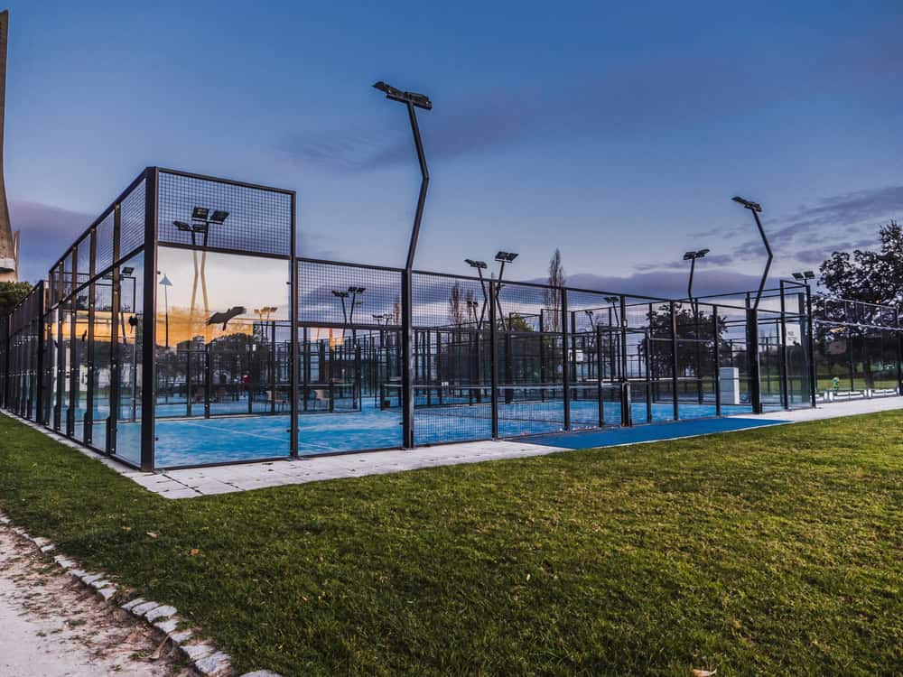 Outdoor padel courts with glass walls at dusk