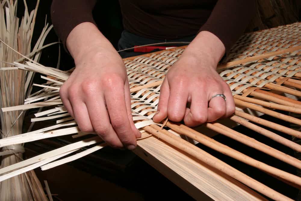 Hands weaving flat reed for basket weaving for beginners